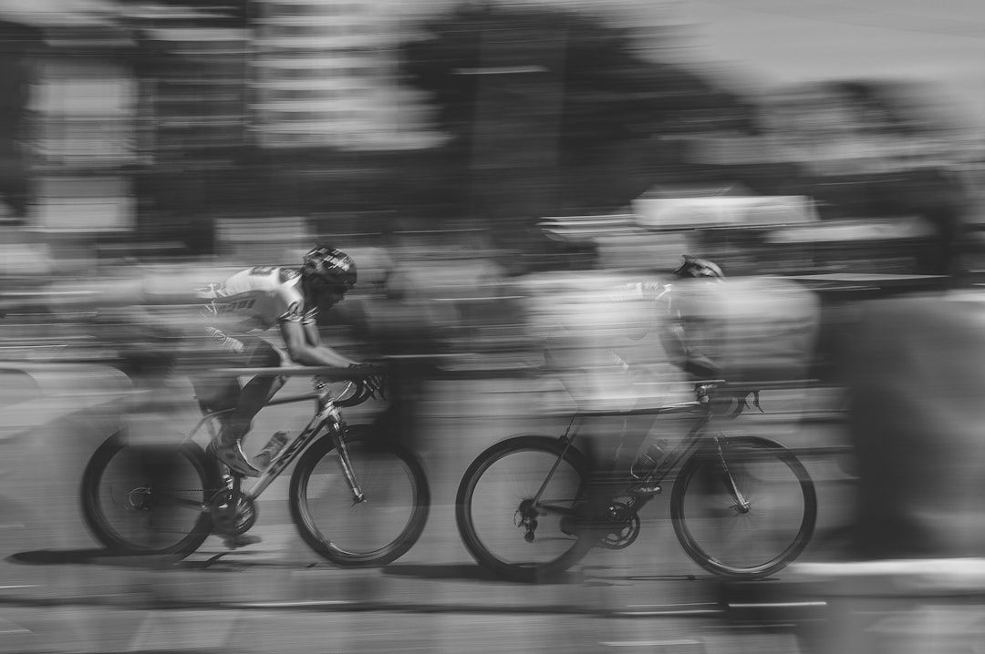 Dos ciclistas compiten juntos en una carretera, captados con movimiento lateral